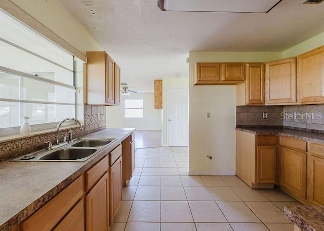 kitchen with decorative backsplash, sink, light tile patterned floors, and ceiling fan