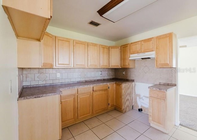 kitchen with light brown cabinets, light tile patterned floors, and backsplash