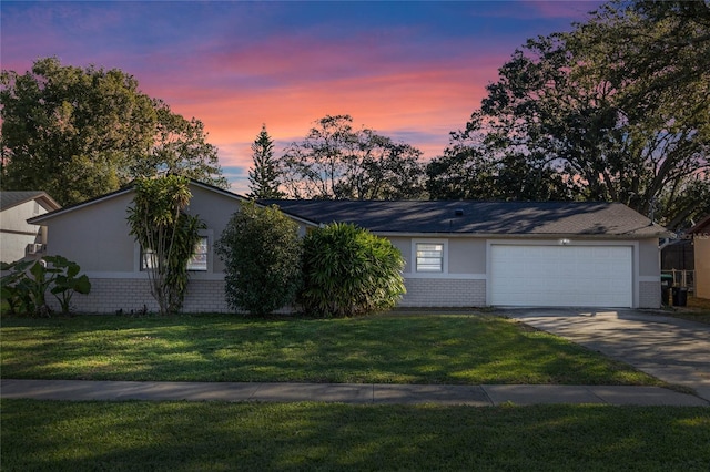 ranch-style house with a yard and a garage