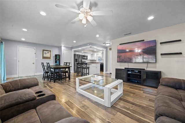 living room with ceiling fan and hardwood / wood-style flooring