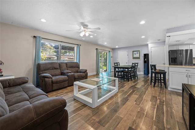 living room with a textured ceiling, wine cooler, ceiling fan, and dark wood-type flooring