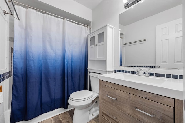 bathroom with wood-type flooring, vanity, tasteful backsplash, and toilet