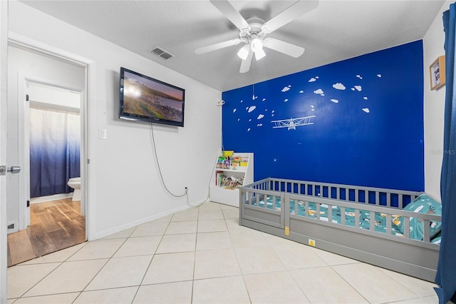 unfurnished bedroom featuring ensuite bath, ceiling fan, and light tile patterned flooring