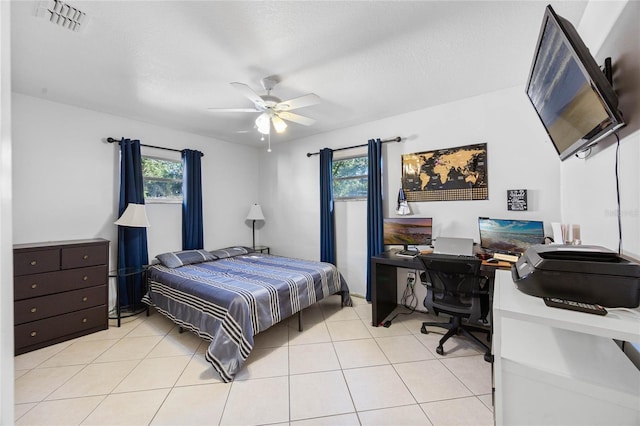 tiled bedroom featuring a textured ceiling and ceiling fan