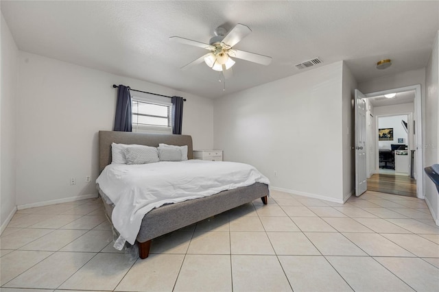 bedroom with light tile patterned floors, a textured ceiling, and ceiling fan