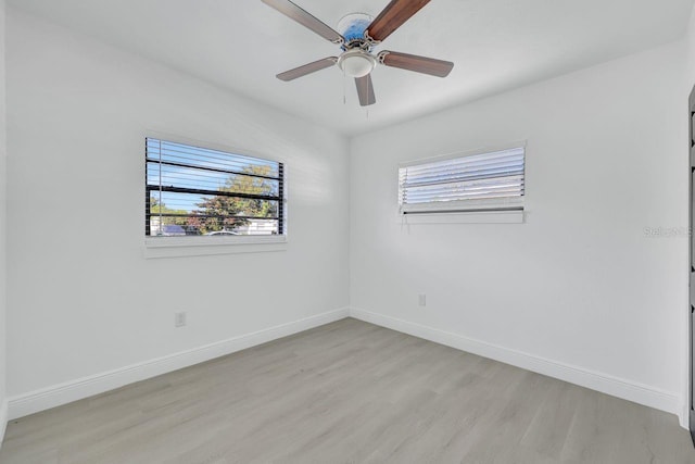 spare room featuring light hardwood / wood-style floors, ceiling fan, and a healthy amount of sunlight