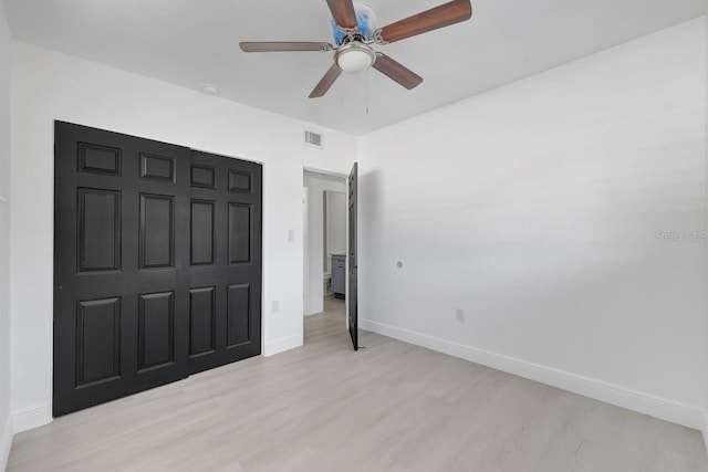 bedroom with a closet, light hardwood / wood-style flooring, and ceiling fan