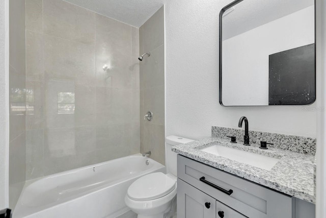 full bathroom featuring a textured ceiling, vanity, toilet, and tiled shower / bath