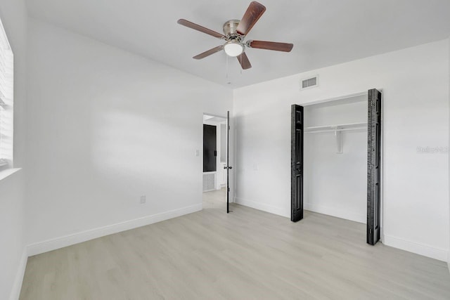 unfurnished bedroom featuring ceiling fan, light hardwood / wood-style floors, and a closet