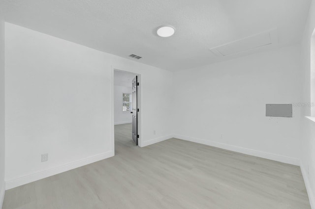 unfurnished room featuring light hardwood / wood-style floors and a textured ceiling