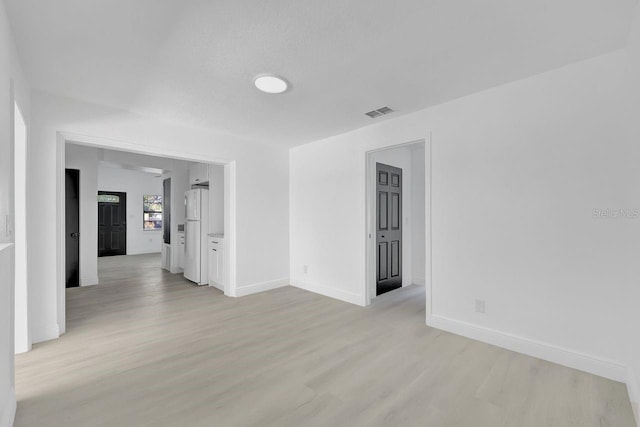 unfurnished room featuring a textured ceiling and light hardwood / wood-style flooring