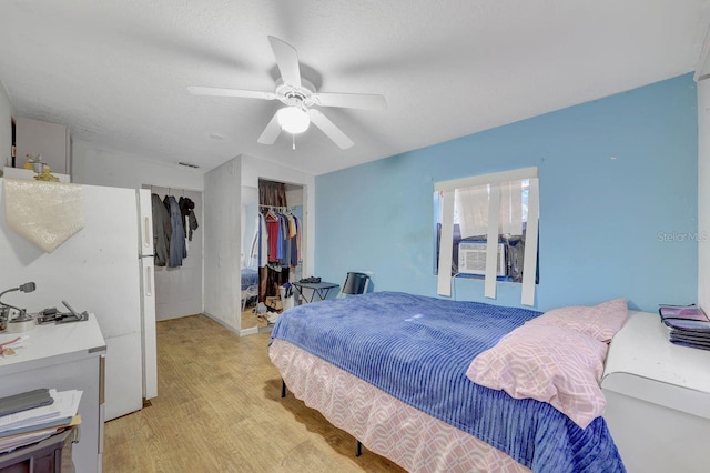 bedroom featuring a textured ceiling, a closet, ceiling fan, and light hardwood / wood-style floors