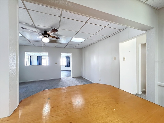 carpeted spare room featuring ceiling fan and a drop ceiling