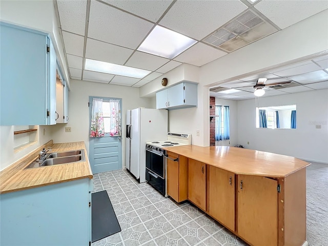 kitchen featuring a wealth of natural light, electric range, sink, and a paneled ceiling