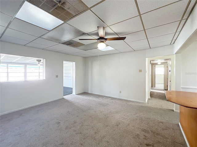 unfurnished room with a paneled ceiling, ceiling fan, and light carpet