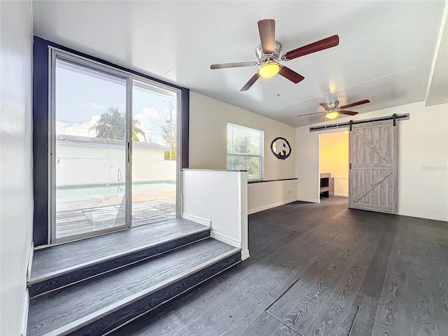 interior space with a barn door and dark hardwood / wood-style floors