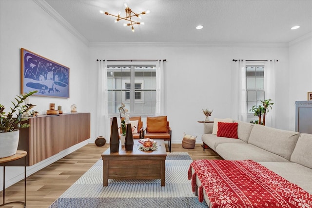 living room featuring light hardwood / wood-style flooring, an inviting chandelier, a textured ceiling, and ornamental molding