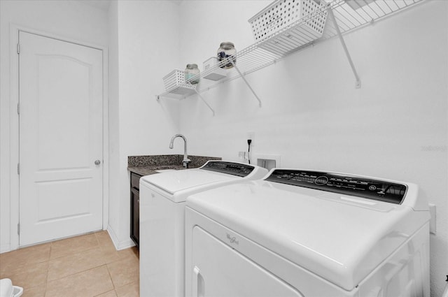 laundry area with sink, light tile patterned flooring, cabinets, and independent washer and dryer