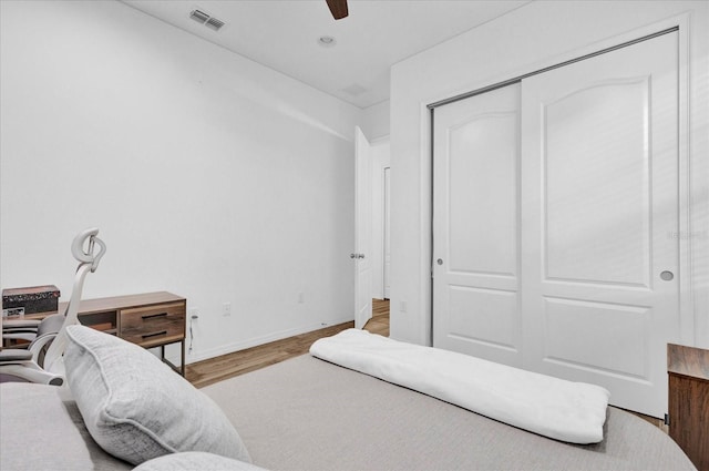 bedroom with hardwood / wood-style flooring, a closet, and ceiling fan