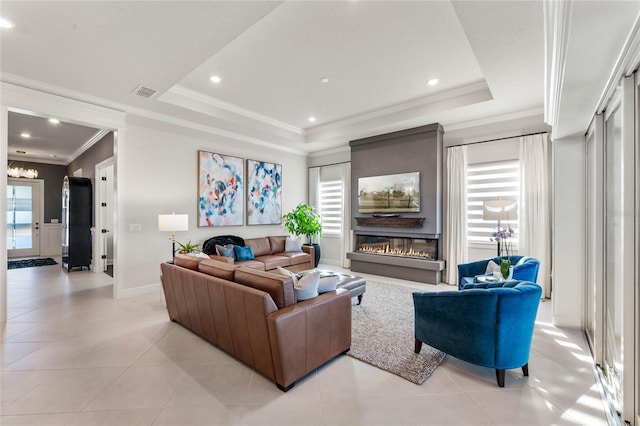 tiled living room with crown molding and a tray ceiling