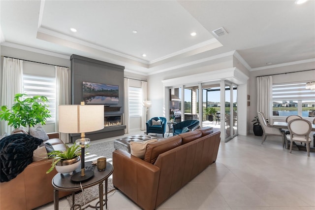 living room featuring a raised ceiling, crown molding, a fireplace, and french doors