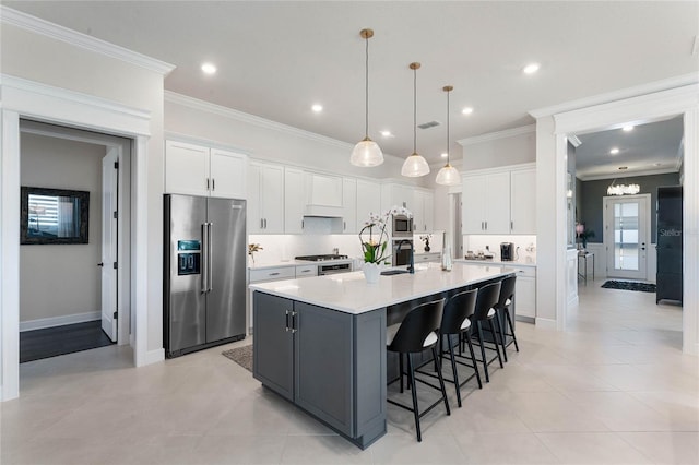 kitchen featuring crown molding, white cabinetry, a center island with sink, and stainless steel appliances