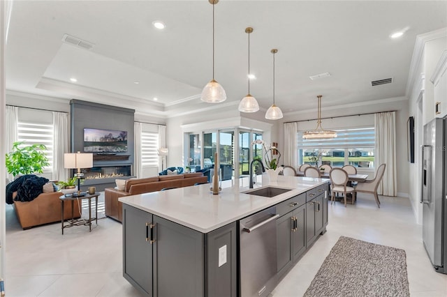 kitchen with appliances with stainless steel finishes, pendant lighting, a healthy amount of sunlight, and sink