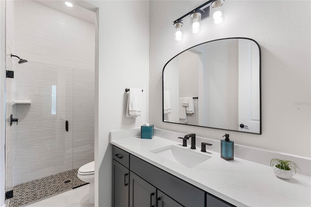 bathroom featuring vanity, toilet, and a shower with shower door