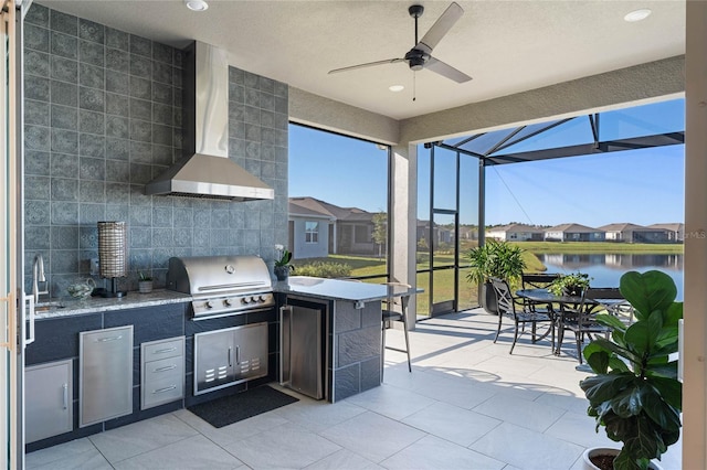 view of patio / terrace with ceiling fan, an outdoor kitchen, a lanai, area for grilling, and a water view