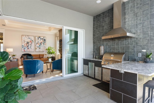 kitchen with light stone countertops, light tile patterned flooring, tile walls, and wall chimney range hood