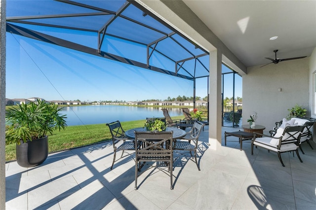 view of patio / terrace featuring a water view, ceiling fan, and a lanai