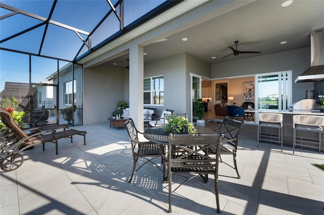 view of patio with glass enclosure, ceiling fan, and grilling area