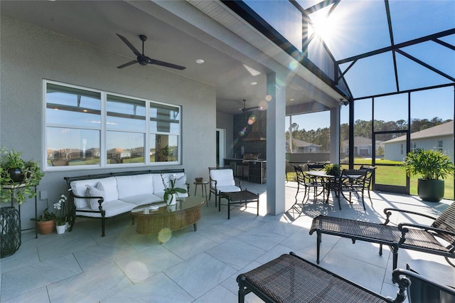 view of patio / terrace featuring an outdoor hangout area, an outdoor kitchen, glass enclosure, and ceiling fan