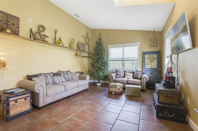 living room with dark tile patterned floors and lofted ceiling