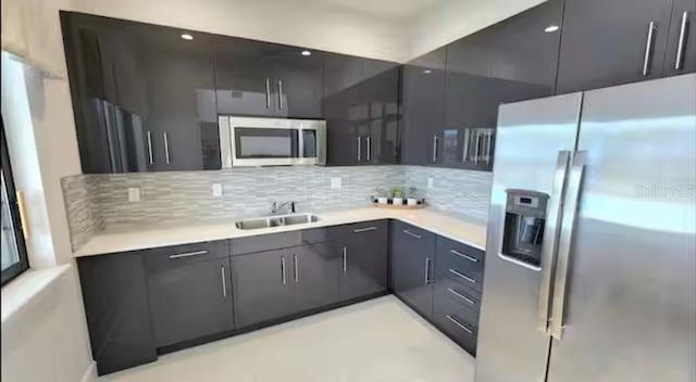 kitchen with appliances with stainless steel finishes, backsplash, and sink