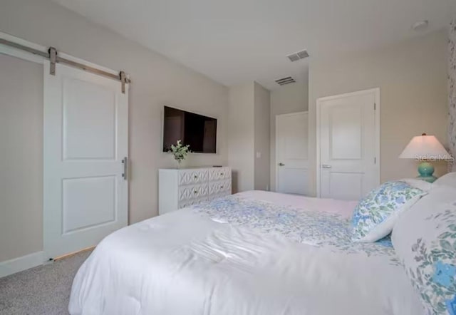 bedroom with a barn door, a closet, and carpet