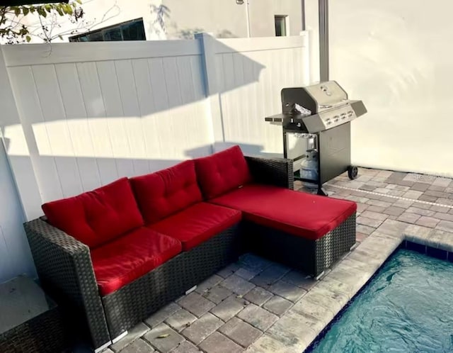 view of patio / terrace featuring outdoor lounge area, a fenced in pool, and grilling area