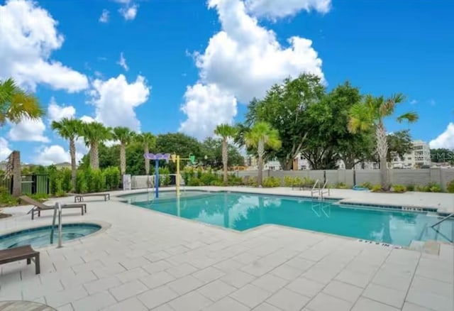 view of swimming pool featuring a community hot tub and a patio