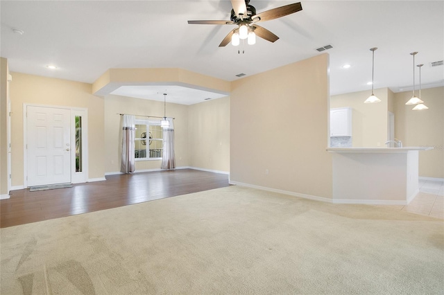 unfurnished living room with light wood-type flooring and ceiling fan