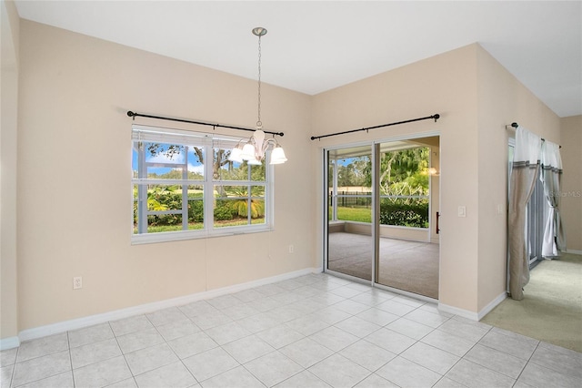 unfurnished dining area featuring a notable chandelier and light carpet