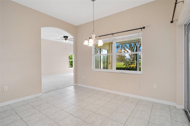 spare room with light tile patterned floors and ceiling fan with notable chandelier