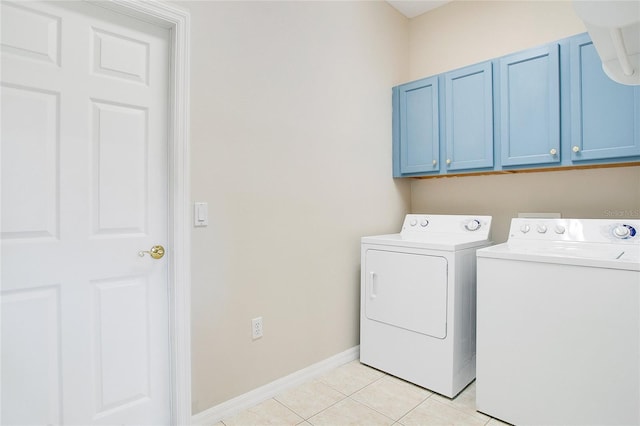 washroom featuring separate washer and dryer, light tile patterned floors, and cabinets