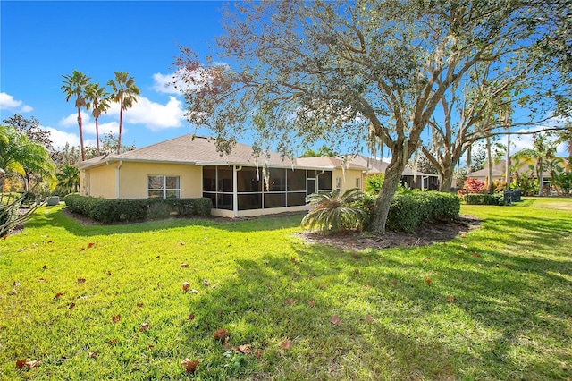 back of property with a lawn and a sunroom