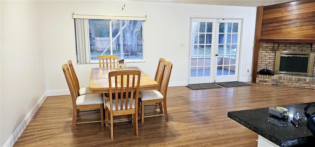 dining area with hardwood / wood-style flooring and a brick fireplace