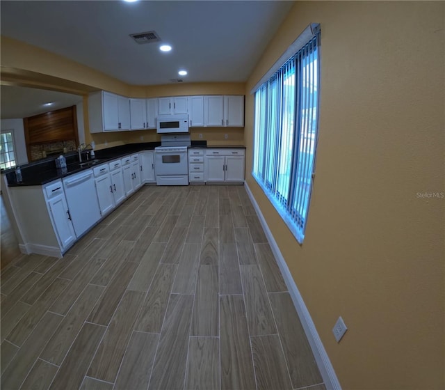 1859 Lake Hill Cir, Orlando, FL 32818 - kitchen featuring white appliances, dark countertops, wood tiled floors, white cabinetry, and recessed lighting