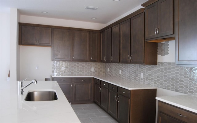 kitchen with tasteful backsplash, sink, and dark brown cabinets