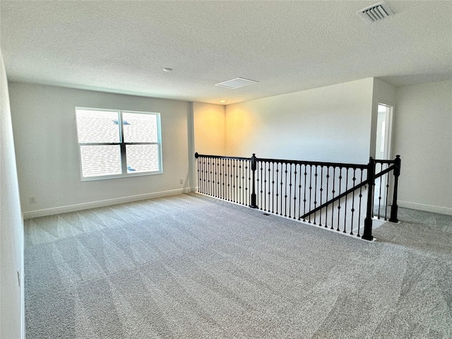 carpeted spare room with a textured ceiling