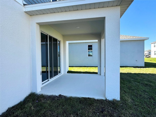 doorway to property featuring a patio area and a yard