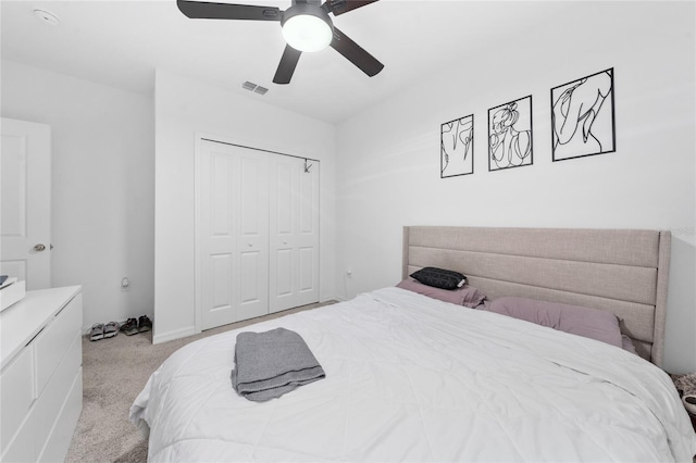 bedroom with ceiling fan, light colored carpet, and a closet