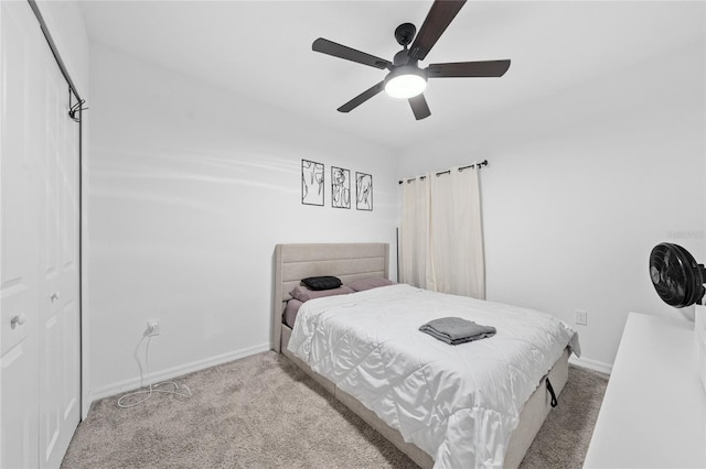 bedroom with ceiling fan, a closet, and light carpet